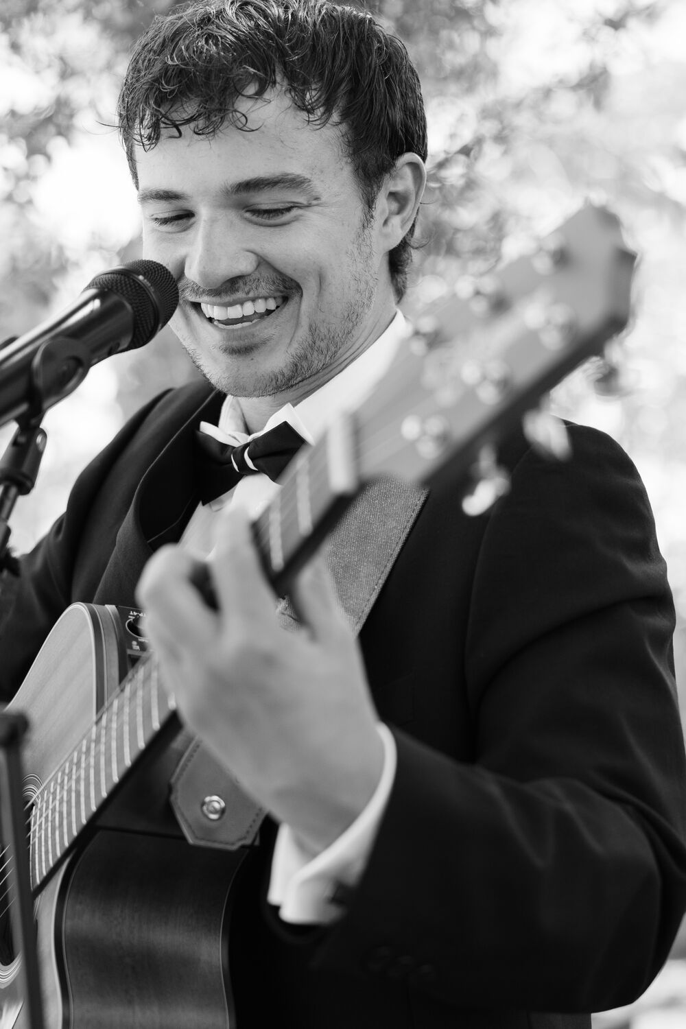 Close portrait of Genie singing and playing guitar